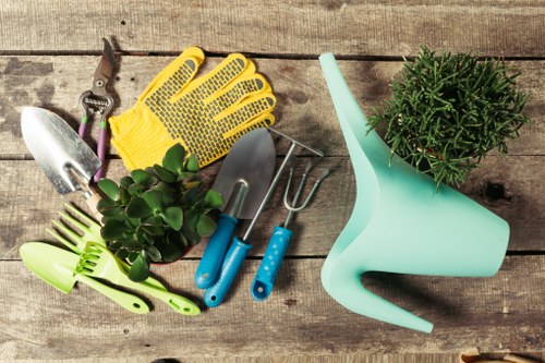 Front view of trimmed hedge and gardener preparing tools
